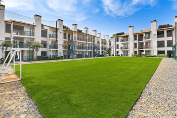 a large green lawn in front of an apartment building